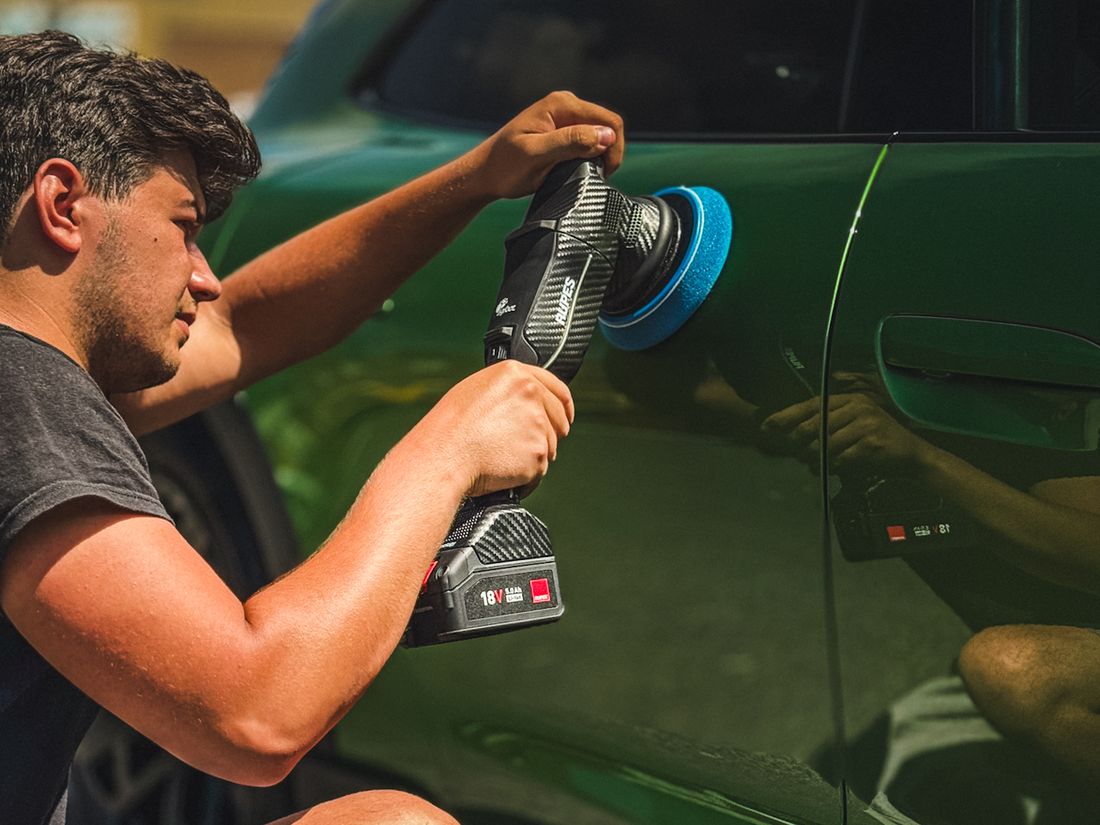 Medewerker van Limitless Shinez poleert een groene auto